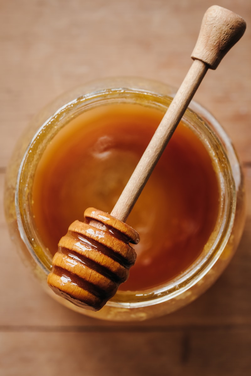 Golden honey being drizzled into a jar